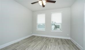 1905 Lonestar Brook Lane Houston, TX 77080 - Photo 15 of 23 an empty room with wooden floor chandelier fan and window