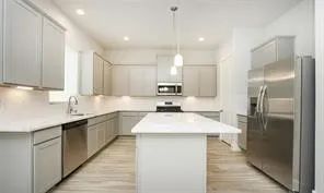 a kitchen with stainless steel appliances kitchen island a sink stove and refrigerator