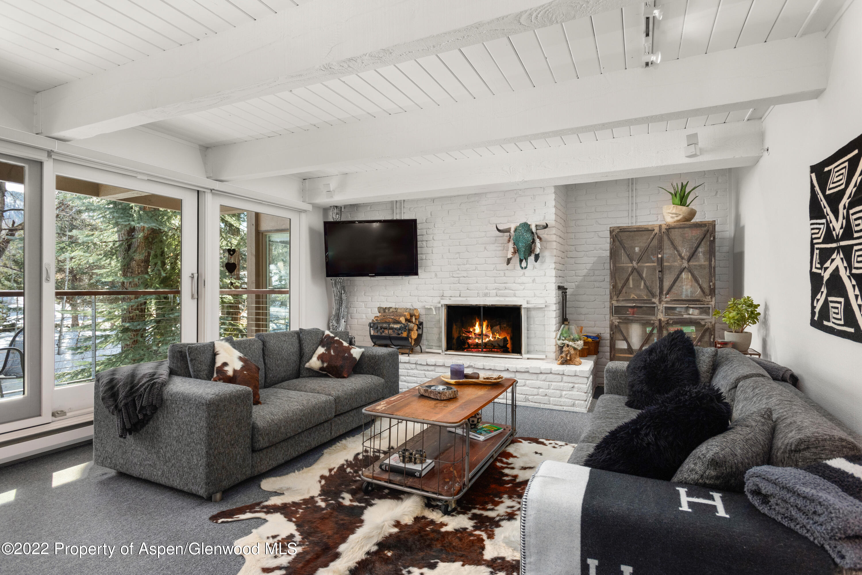 a living room with furniture a large window and a fireplace