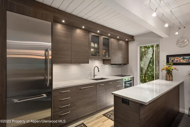 a kitchen with a sink a refrigerator and cabinets