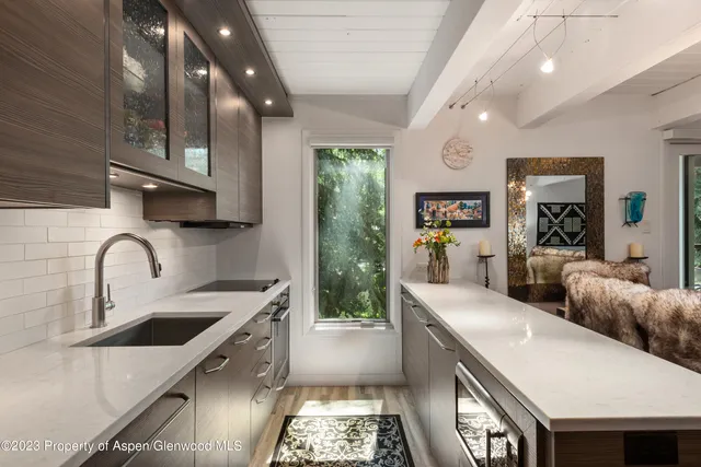 a large kitchen with stainless steel appliances granite countertop a lot of counter space and a sink