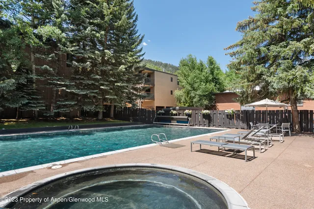 a view of a patio with a table and chairs under an umbrella