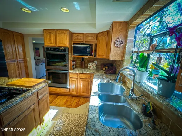 a kitchen with stainless steel appliances granite countertop a sink and a stove