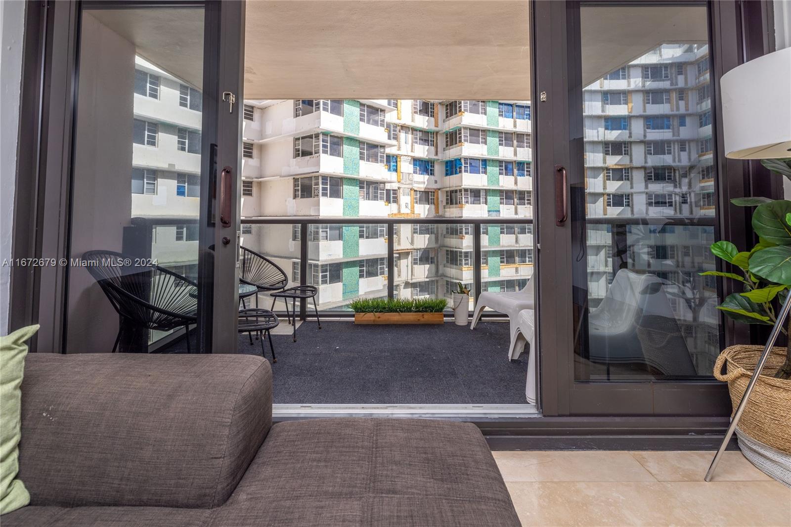 5225 Collins Avenue, Unit 1114 Miami Beach, FL 33140 - Photo 17 of 49 a living room with furniture and a floor to ceiling window