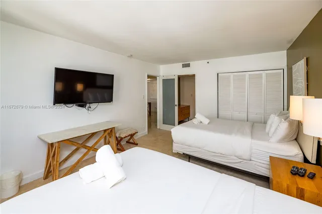 a bedroom with a bed and a flat screen tv