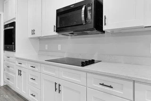 a kitchen with stainless steel appliances a stove sink microwave and cabinets