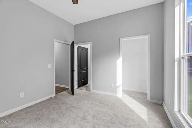 an empty room with closet and windows