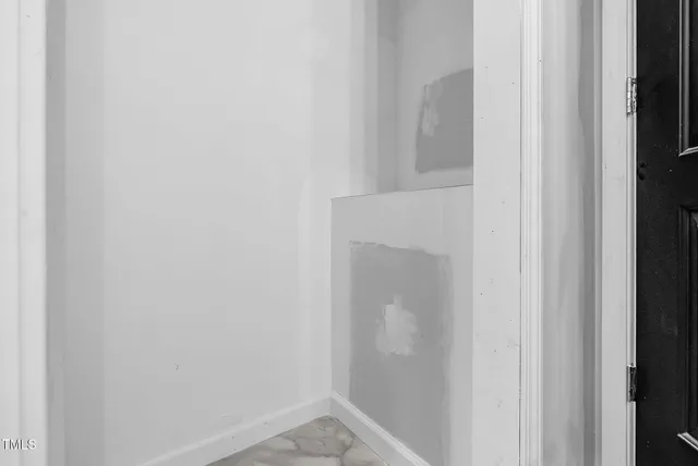 an empty room with wooden floor and entrance