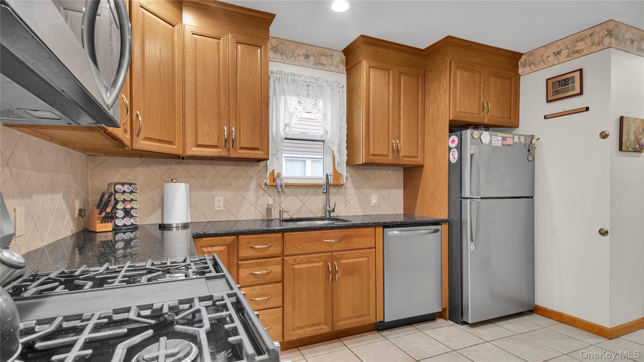 56 Liggett Road Valley Stream, NY 11581 - Photo 13 of 29 a kitchen with stainless steel appliances granite countertop a refrigerator stove and sink