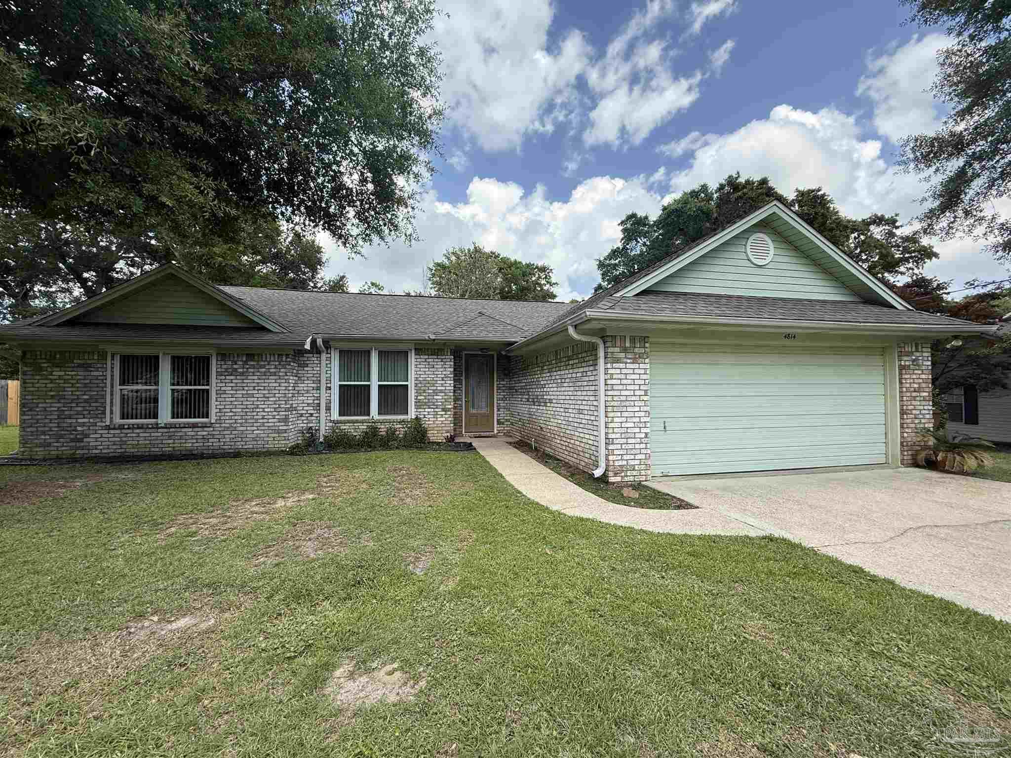 a front view of a house with a garden and yard