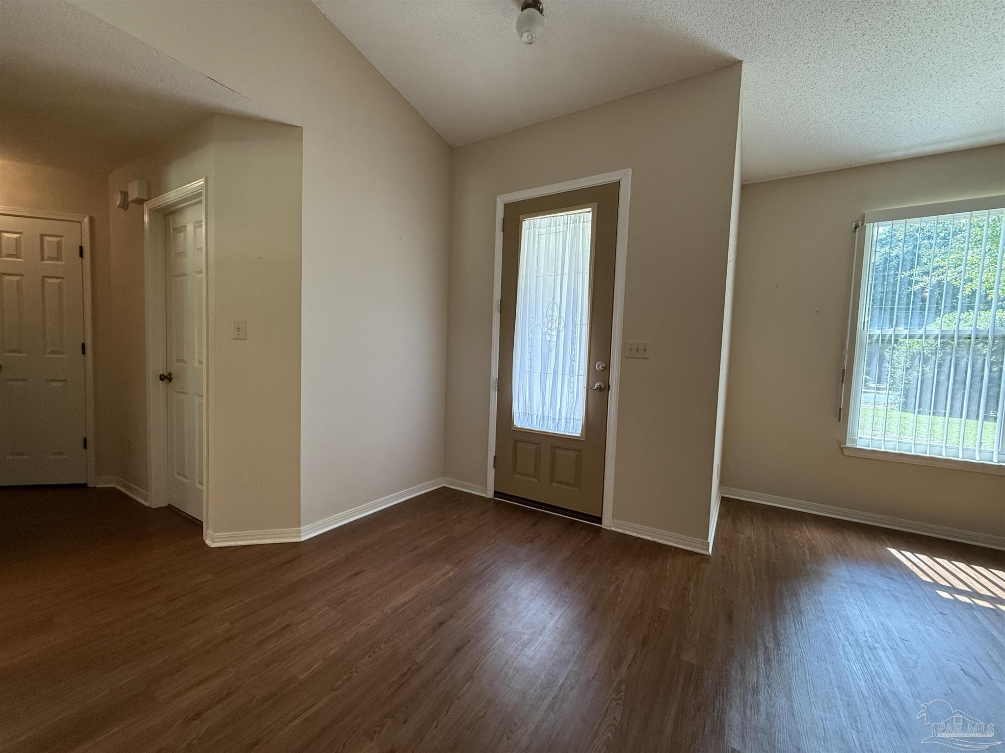 4814 Autumn Drive Pace, FL 32571 - Photo 14 of 52 a view of an empty room with wooden floor and a window