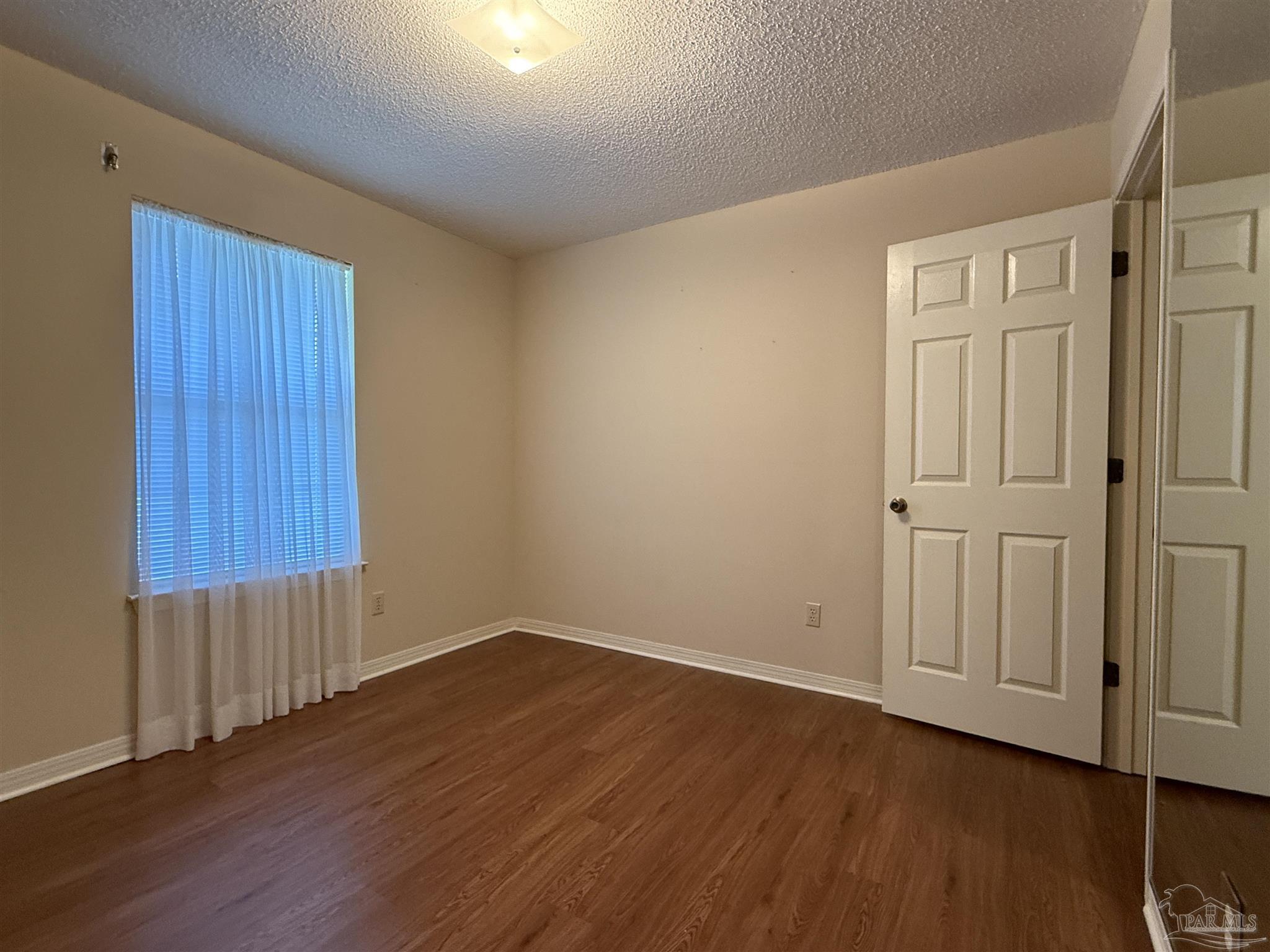 4814 Autumn Drive Pace, FL 32571 - Photo 24 of 52 a view of an empty room with wooden floor