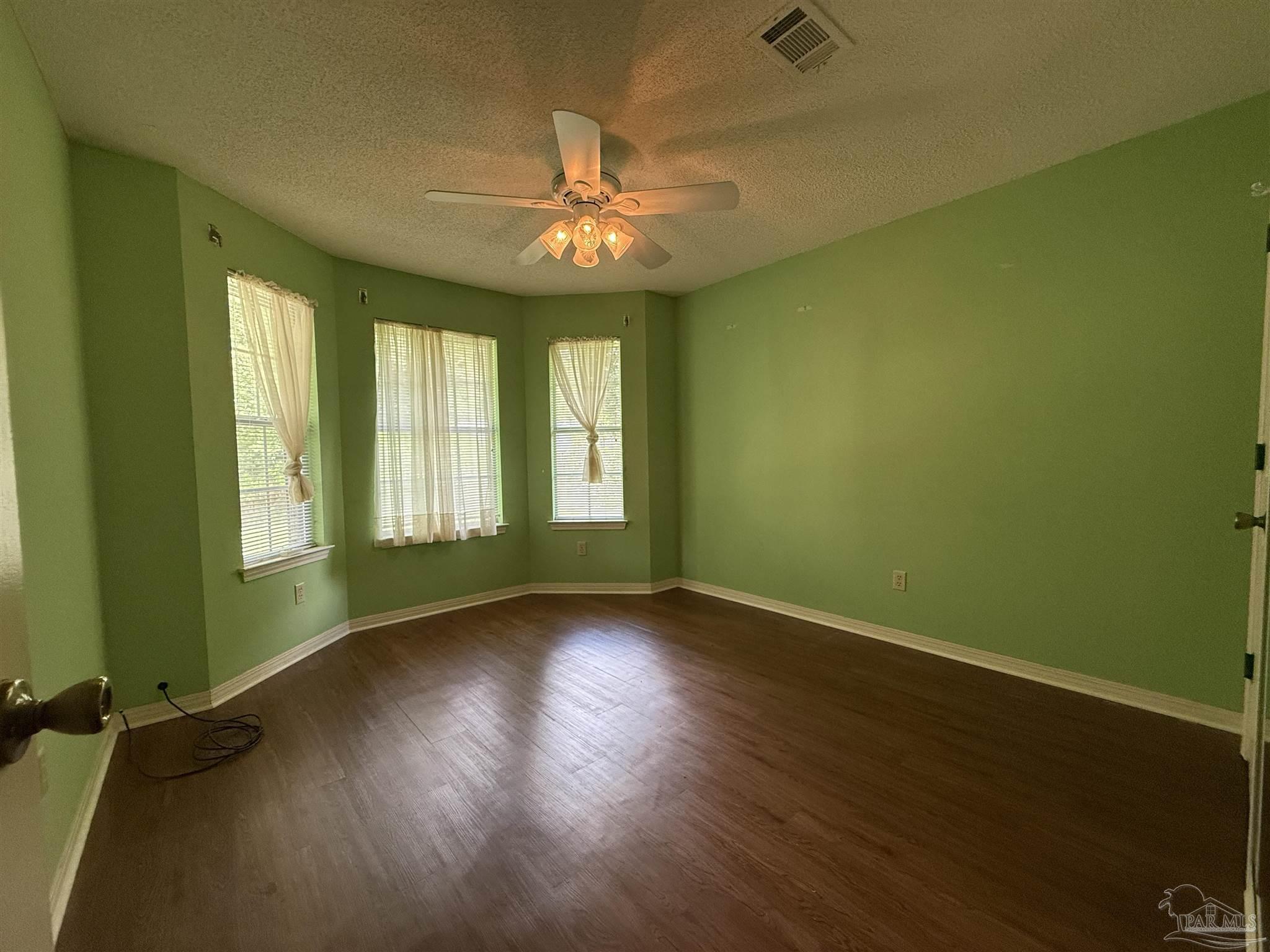 4814 Autumn Drive Pace, FL 32571 - Photo 28 of 52 a view of an empty room with wooden floor and a window
