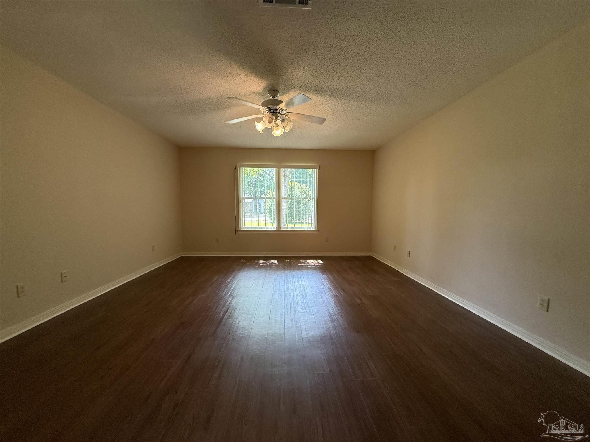 4814 Autumn Drive Pace, FL 32571 - Photo 30 of 52 an empty room with wooden floor and windows