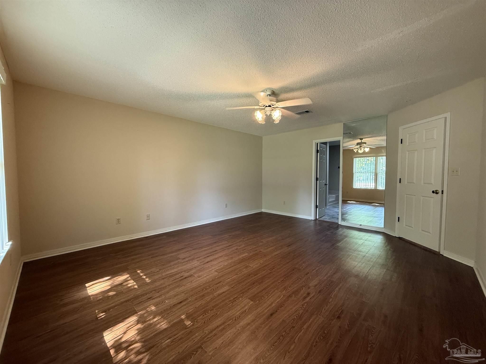 4814 Autumn Drive Pace, FL 32571 - Photo 32 of 52 a view of an empty room with wooden floor and fan