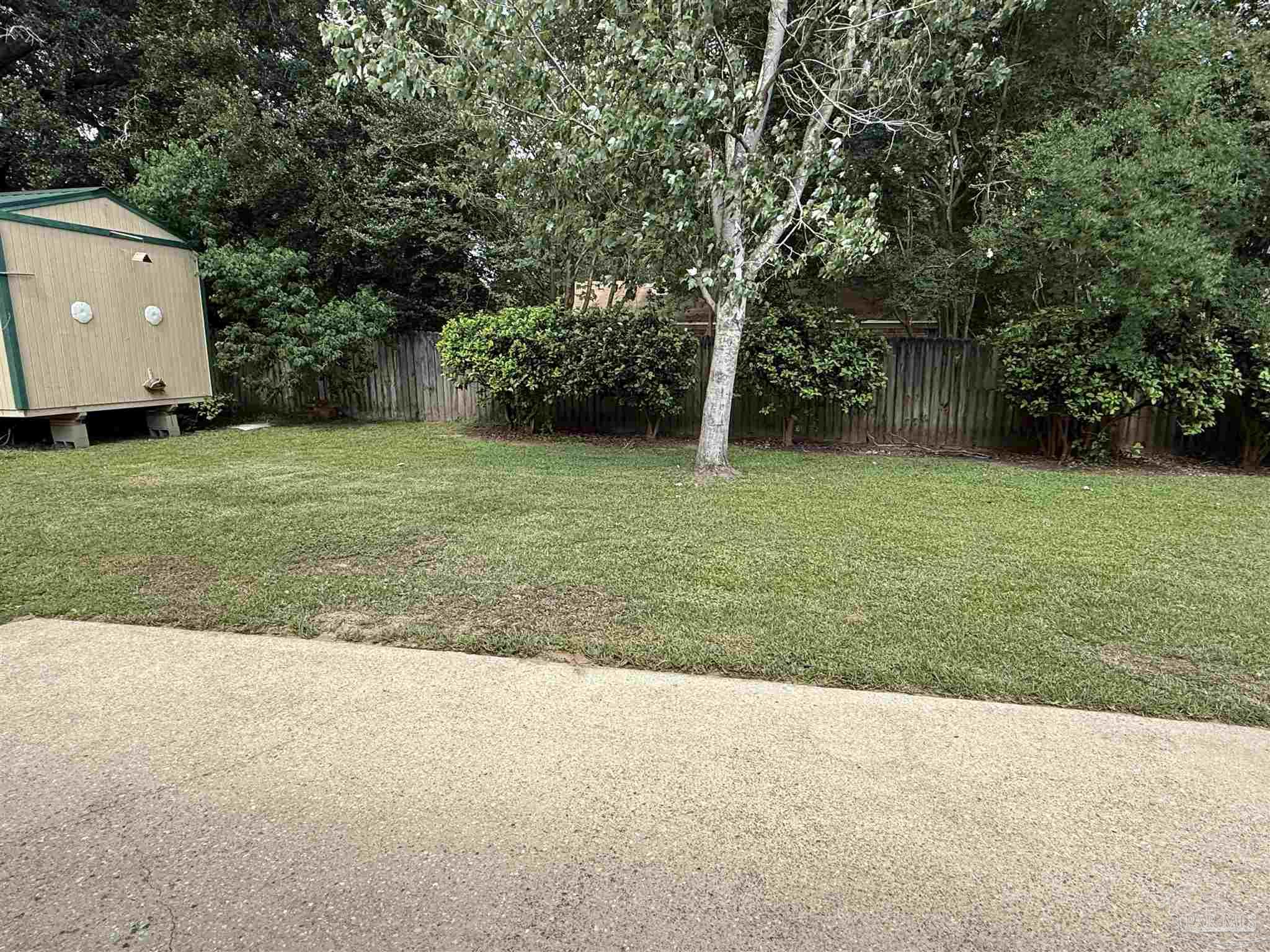 4814 Autumn Drive Pace, FL 32571 - Photo 48 of 52 a backyard of a house with plants and large trees