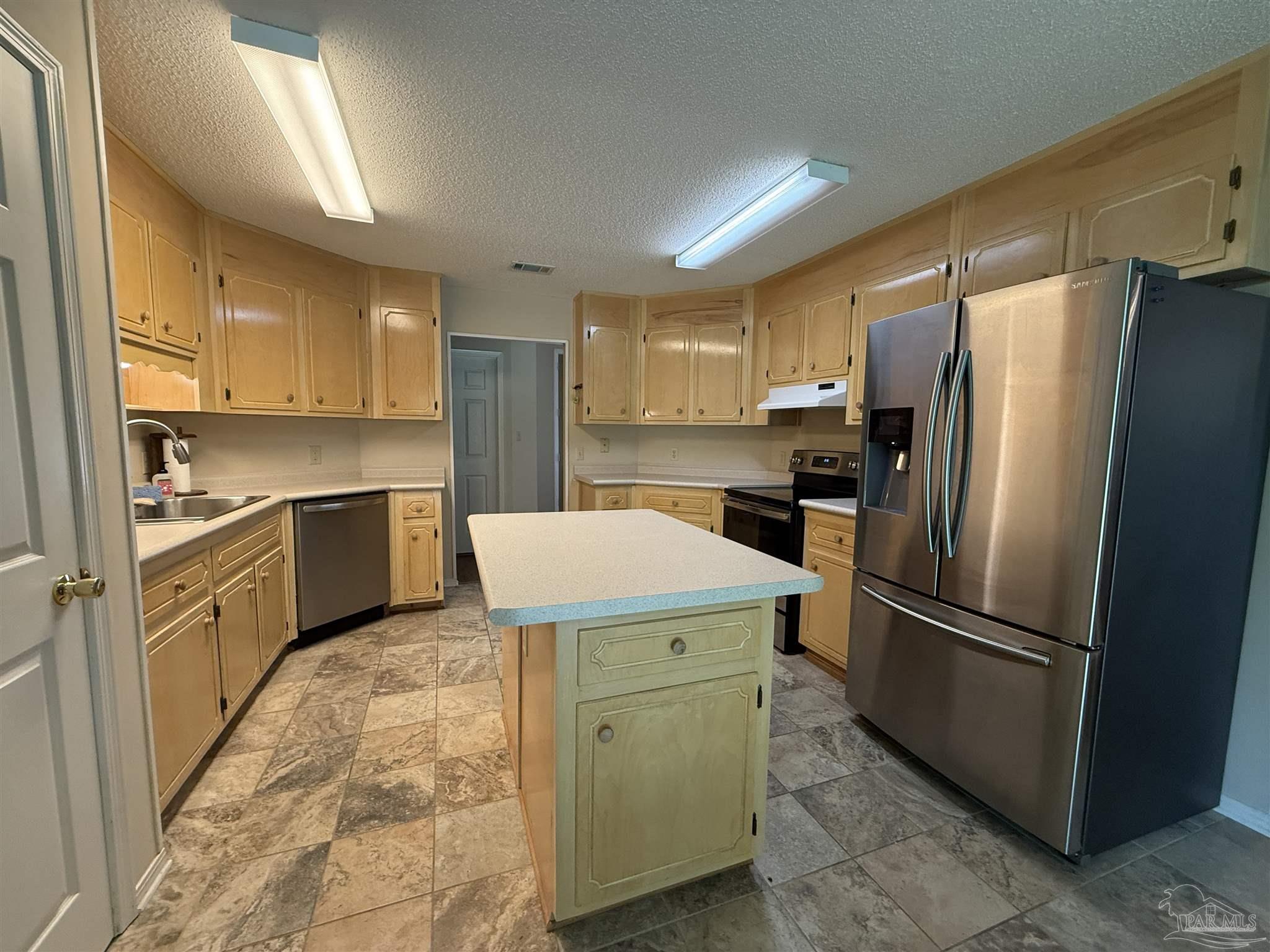 4814 Autumn Drive Pace, FL 32571 - Photo 6 of 52 a kitchen with a refrigerator a sink and cabinets