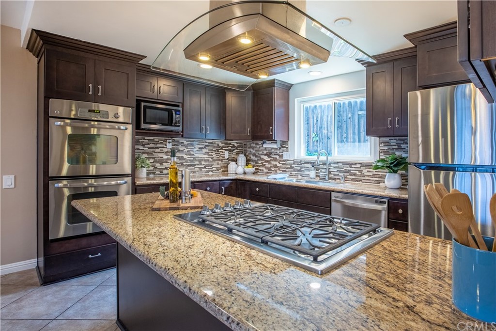 1408 Las Lomas Drive Brea, CA 92821 - Photo 26 of 47 a kitchen with kitchen island granite countertop a stove and a refrigerator