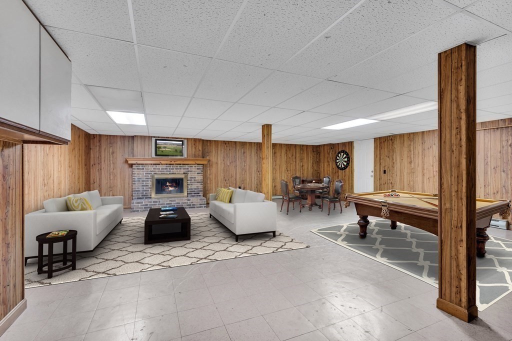 91 Lower Gore Road Webster, MA 01570 - Photo 24 of 37 a living room with furniture a fireplace and gym equipment