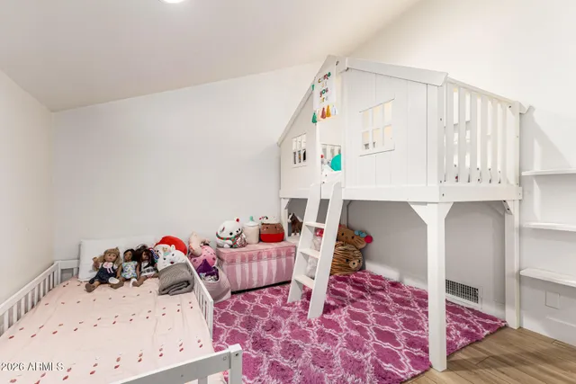 a living room with furniture and a baby crib