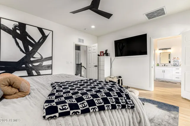 a bedroom with a bed and a flat tv screen on wall
