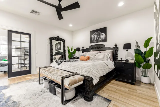 a bedroom with a bed a dresser and next to a window