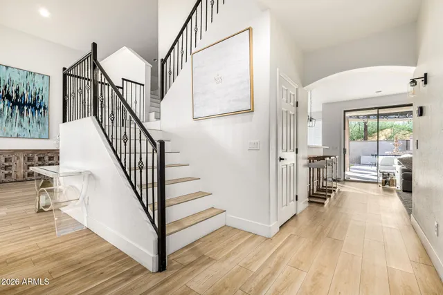 a view of a hallway with wooden floor and staircase