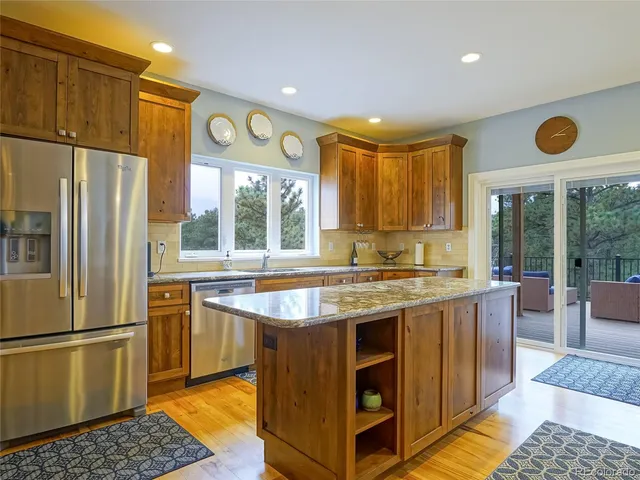 a kitchen with stainless steel appliances granite countertop a stove and a refrigerator