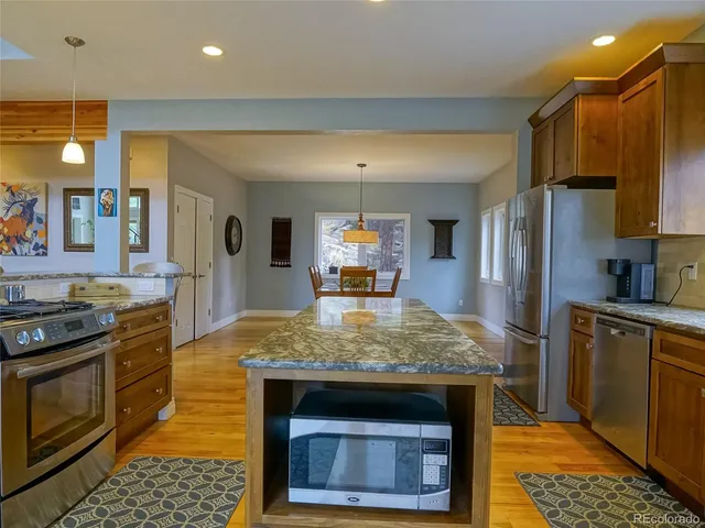 a kitchen with stainless steel appliances granite countertop a stove refrigerator and microwave