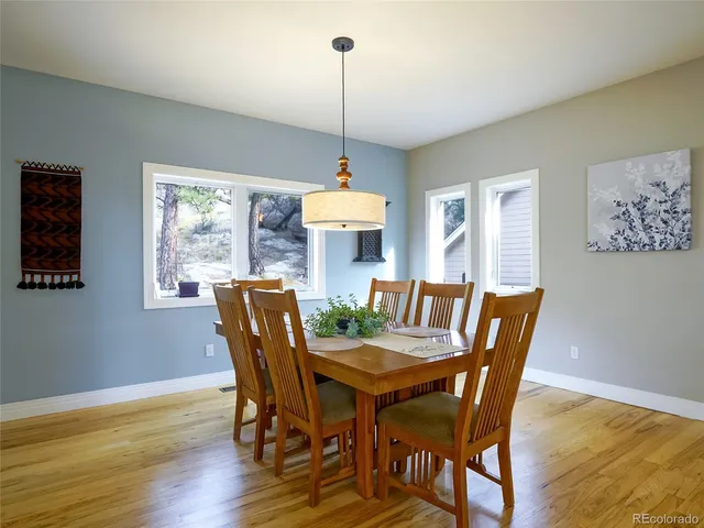 a dining room with furniture window and wooden floor