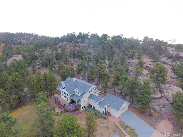 an aerial view of a house with a mountain in the background