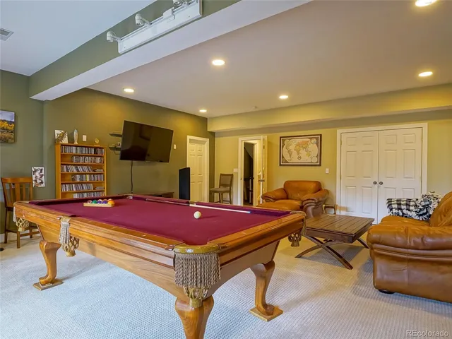 a room with gym equipment pool table and windows