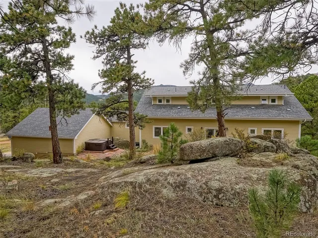 a view of a house with a yard and large tree