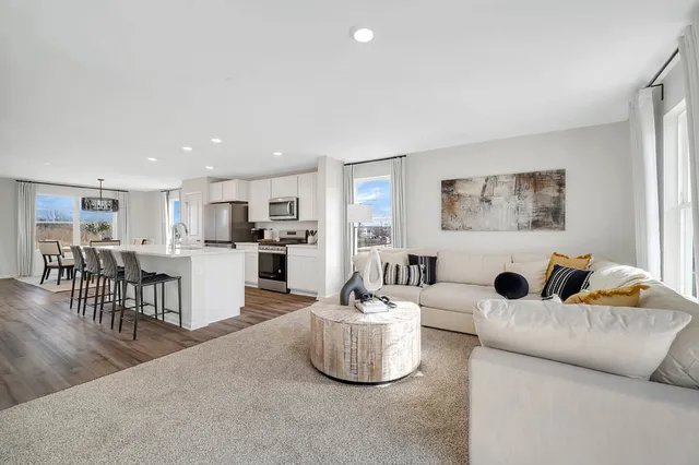 a living room with furniture and kitchen view