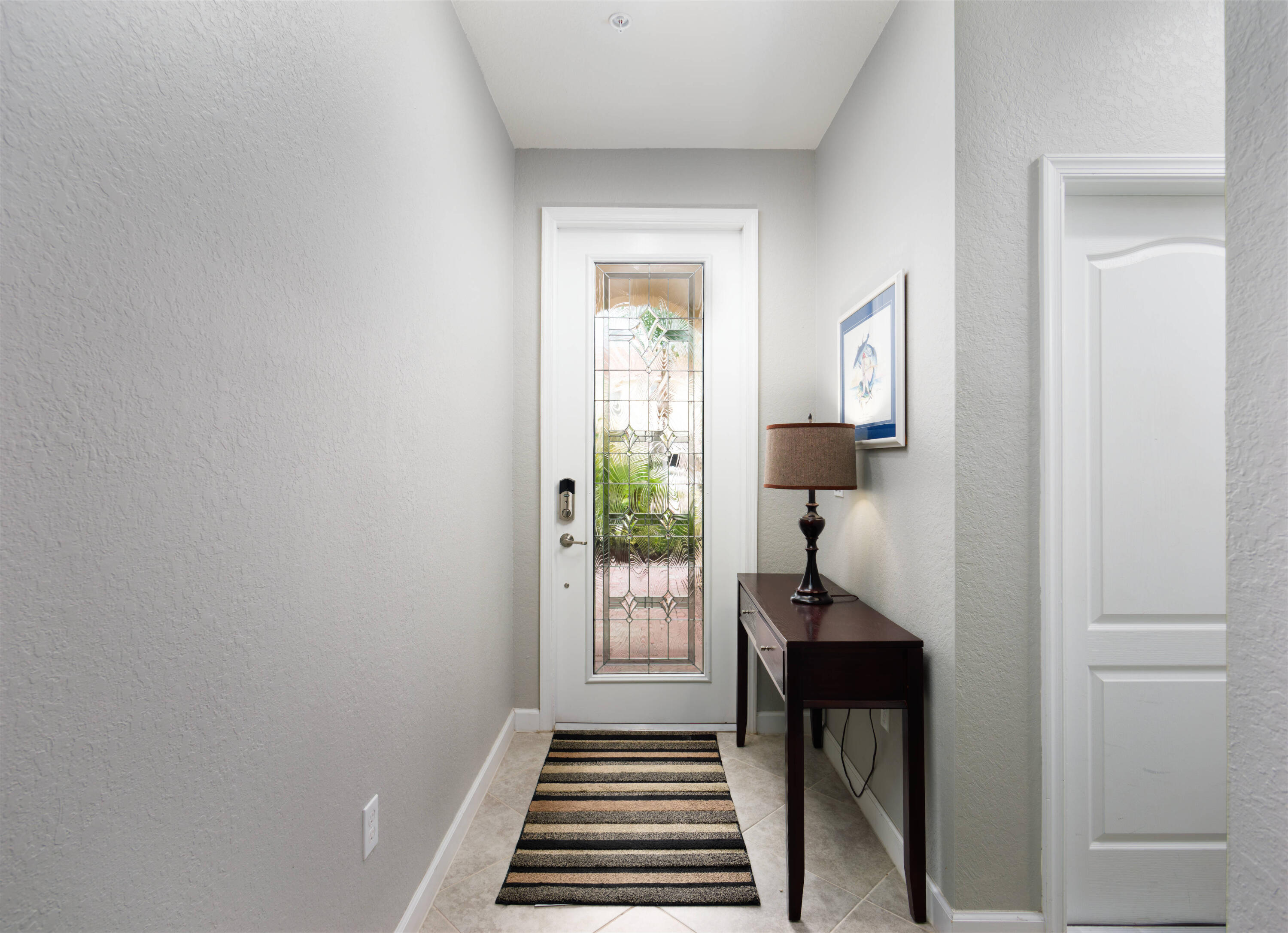 9674 Southwest Purple Martin Way Stuart, FL 34997 - Photo 2 of 21 a hallway with a window and a livingroom