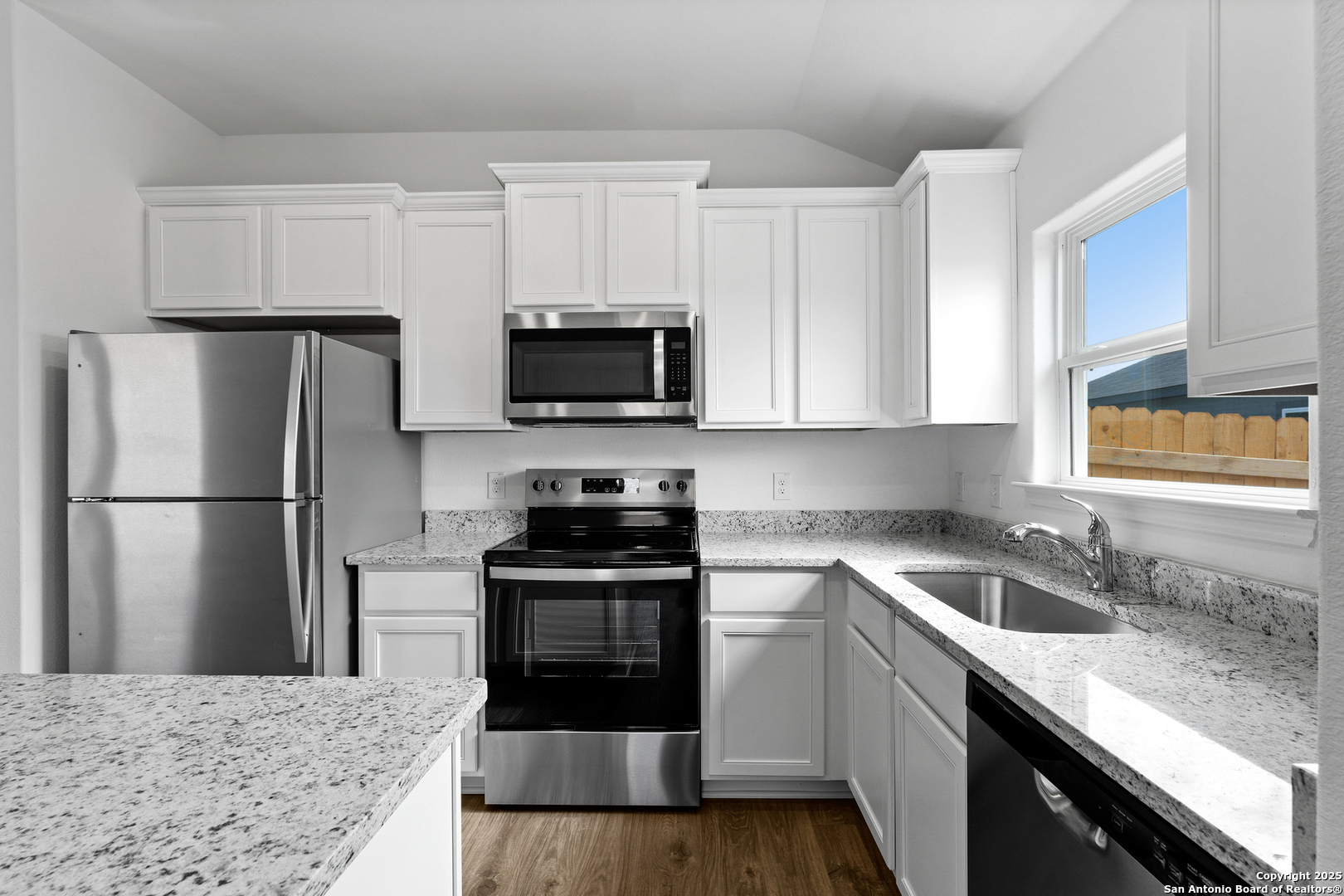 16024 Stratford Cove Lytle, TX 78052 - Photo 7 of 27 a kitchen with kitchen island granite countertop a sink stainless steel appliances and white cabinets