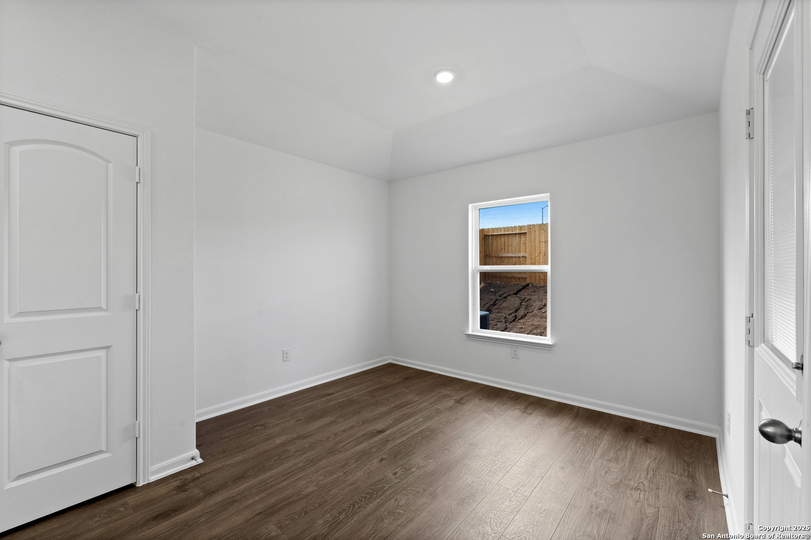 16024 Stratford Cove Lytle, TX 78052 - Photo 9 of 27 a view of an empty room with wooden floor and a window