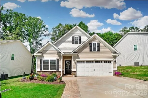 a view of a house with a yard and potted plants
