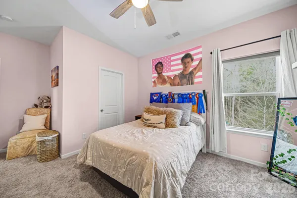 a bedroom with a bed and a painting on the wall