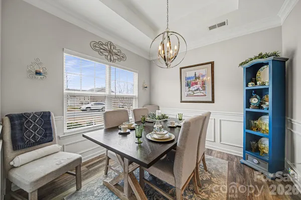 a view of a dining room with furniture wooden floor and a chandelier