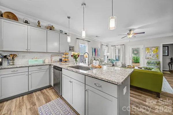 a kitchen with kitchen island granite countertop a sink stove and cabinets