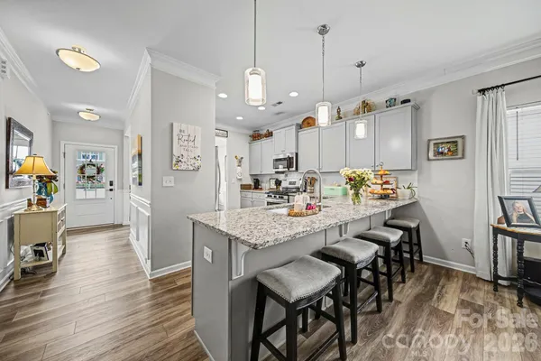 a room with stainless steel appliances kitchen island granite countertop furniture and a dining table