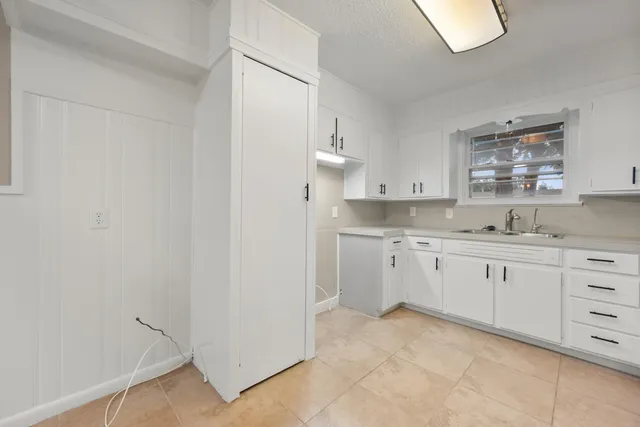 a kitchen with granite countertop white cabinets and sink