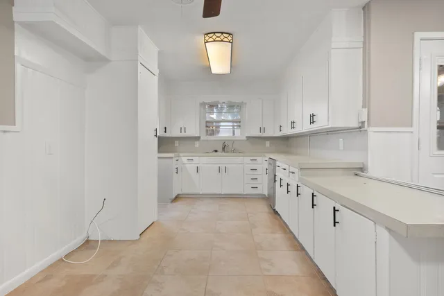a kitchen with granite countertop white cabinets and white appliances