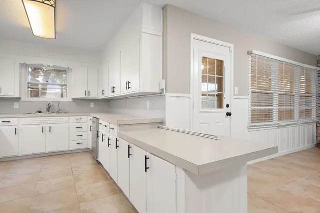 a kitchen with granite countertop white cabinets and white appliances