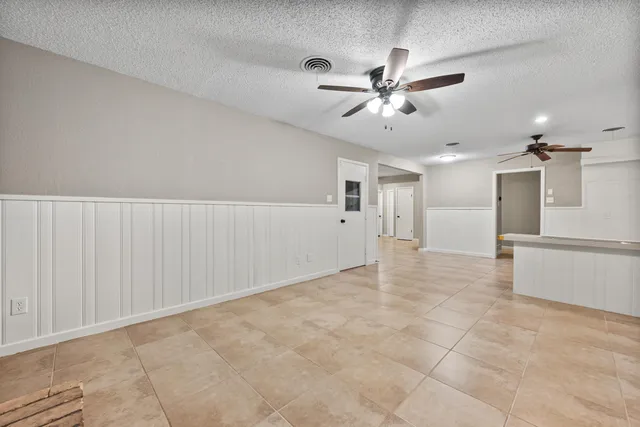 a view of an empty room and kitchen view