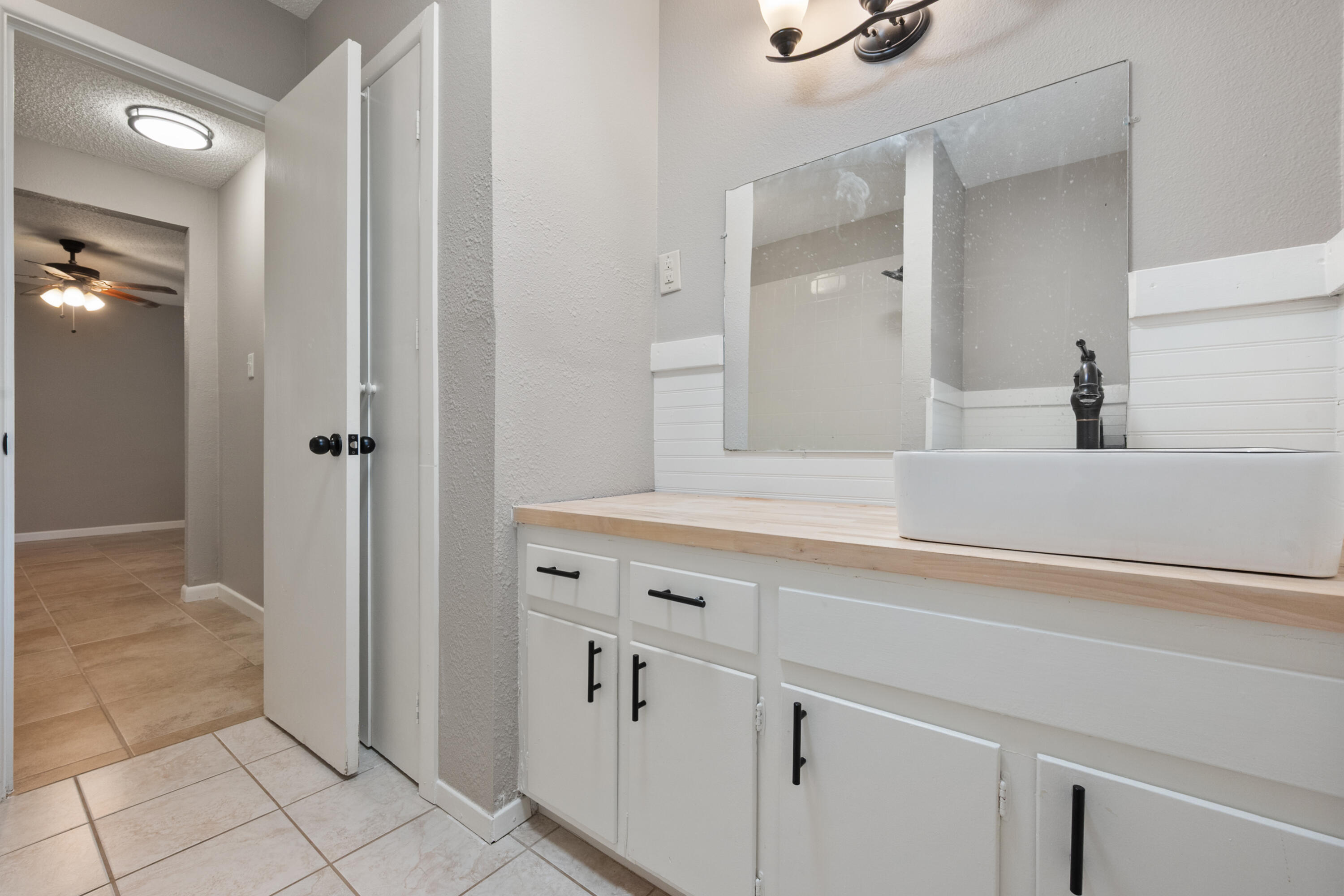 4915 11th Street Lubbock, TX 79416 - Photo 23 of 28 a bathroom with a double vanity sink and mirror