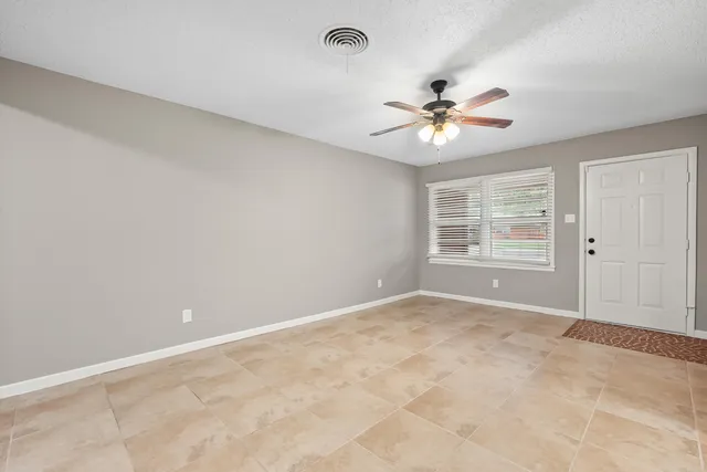 a view of a room with a ceiling fan and a window