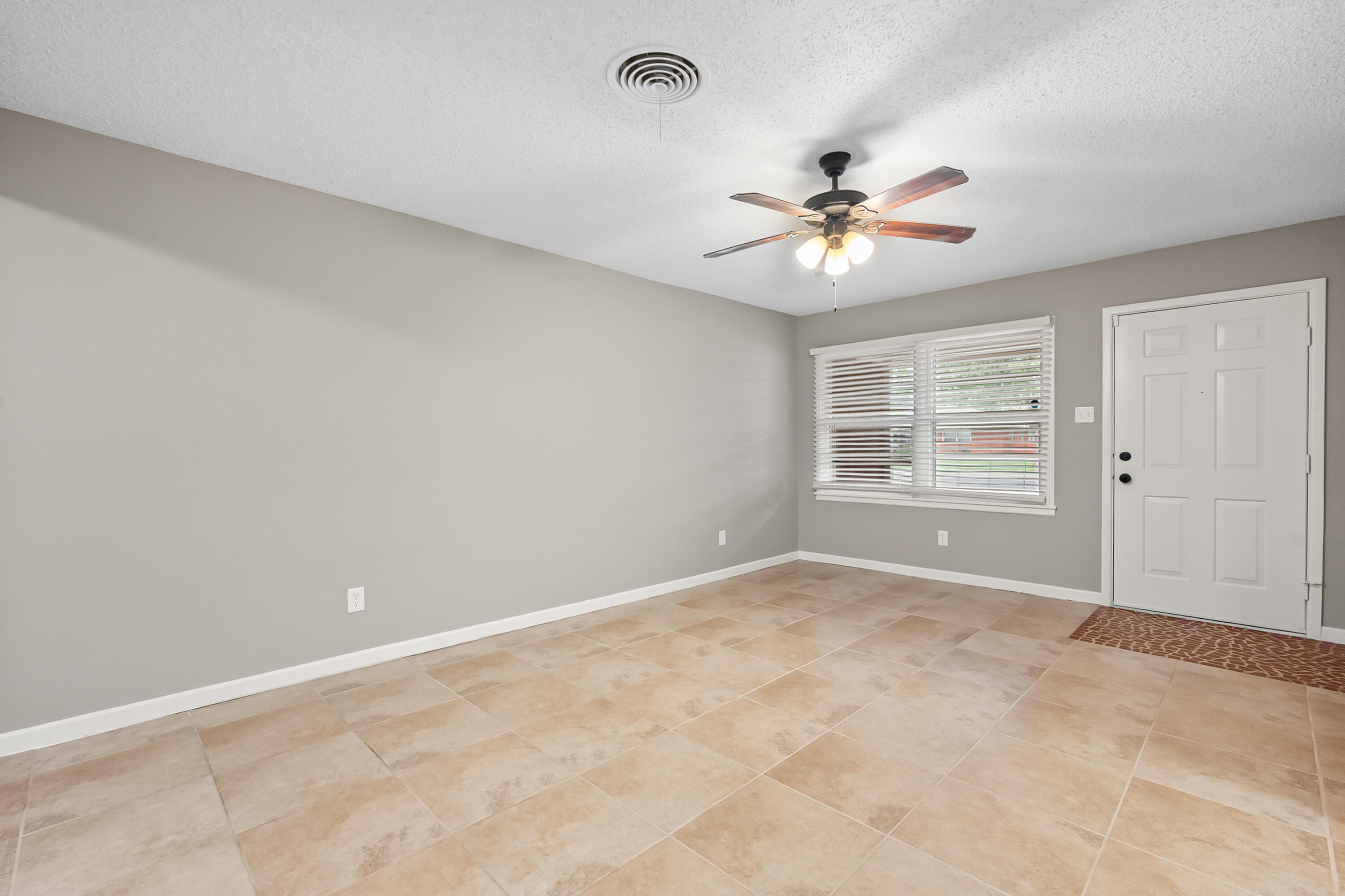 4915 11th Street Lubbock, TX 79416 - Photo 7 of 28 a view of a room with a ceiling fan and a window
