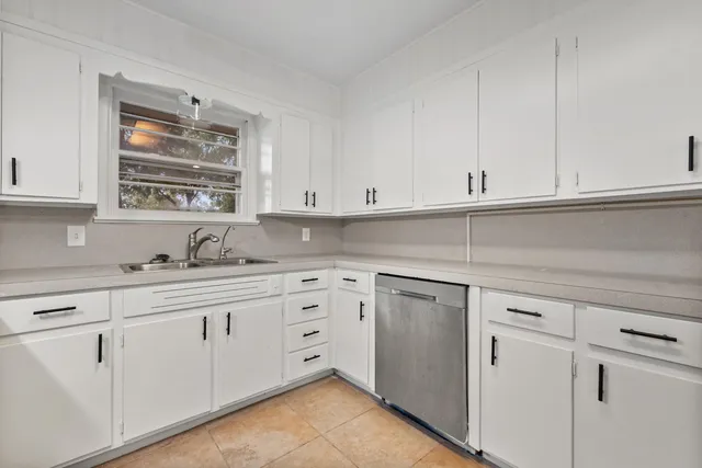 a kitchen with white cabinets and white appliances